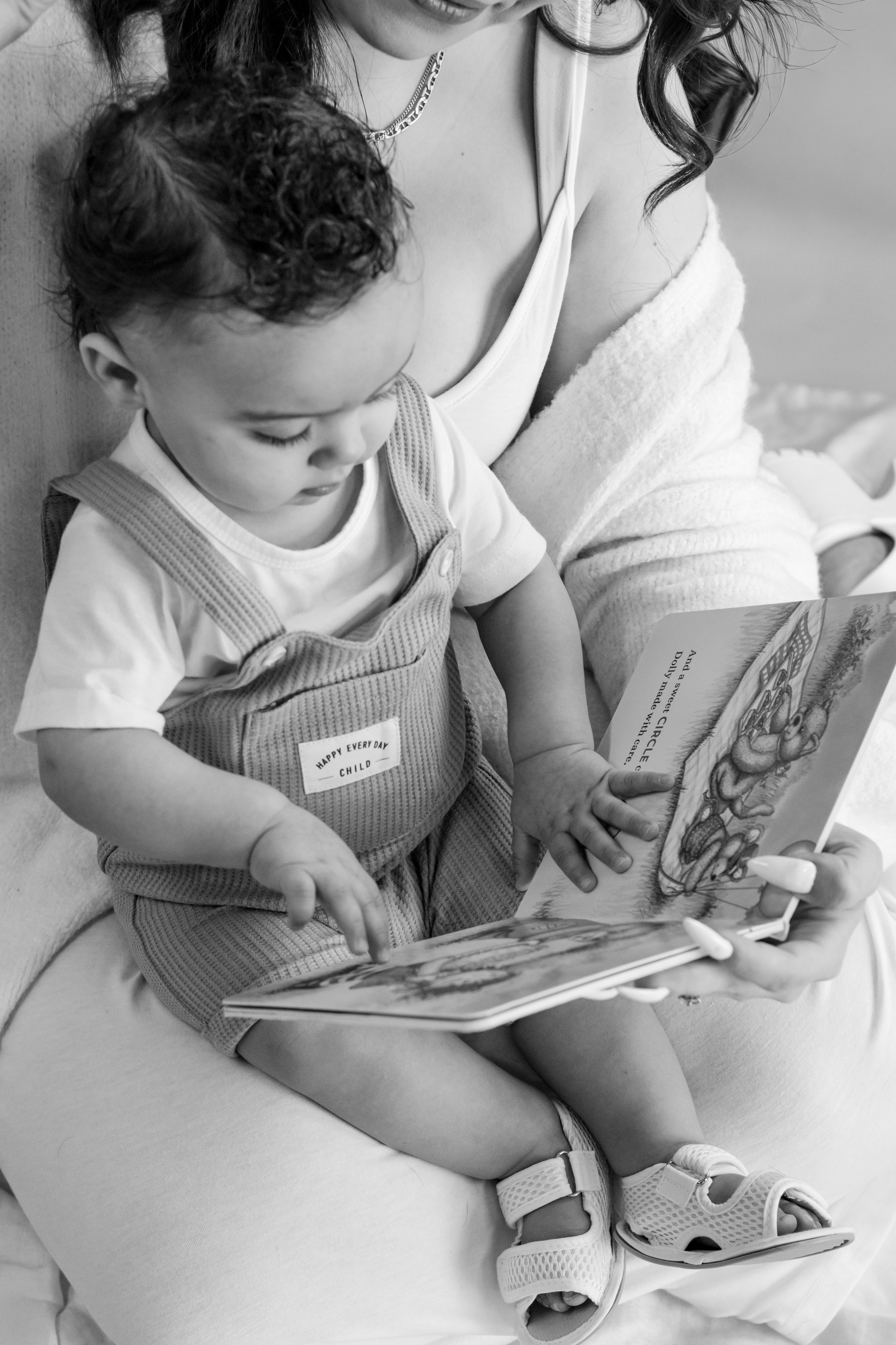 Black and white photo of a mother and baby reading a picture book photographed near JBLM in Roy WA studio by Roy photographer
