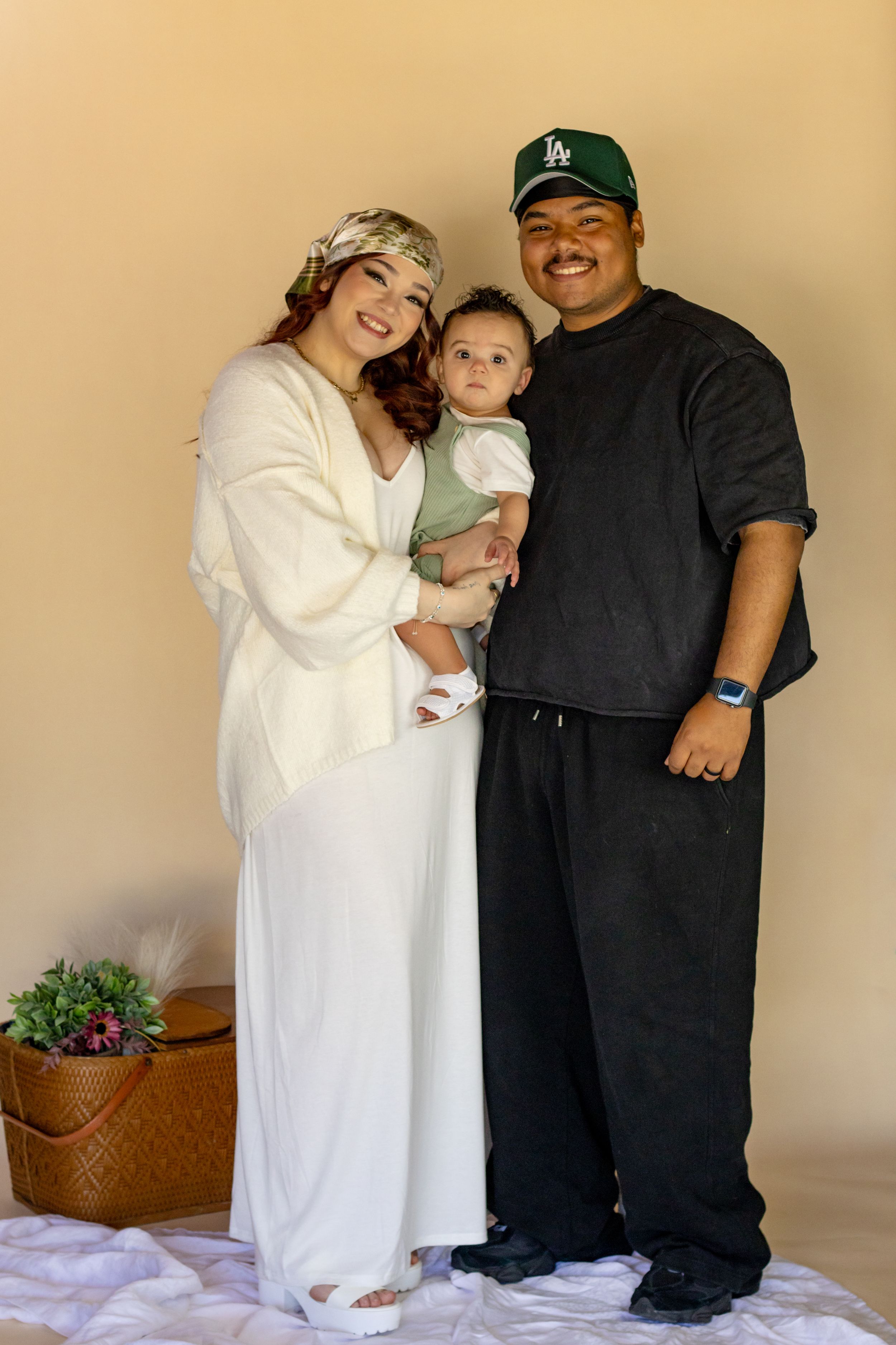 Family portrait of smiling parents holding their baby taken by pierce county photographer in roy washington studio