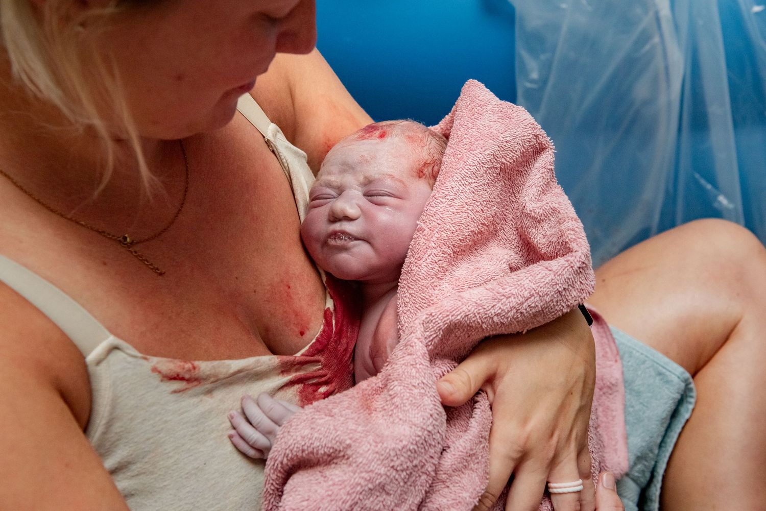 A series of tender moments showing a newborn baby being wrapped in a soft pink towel after bath time.