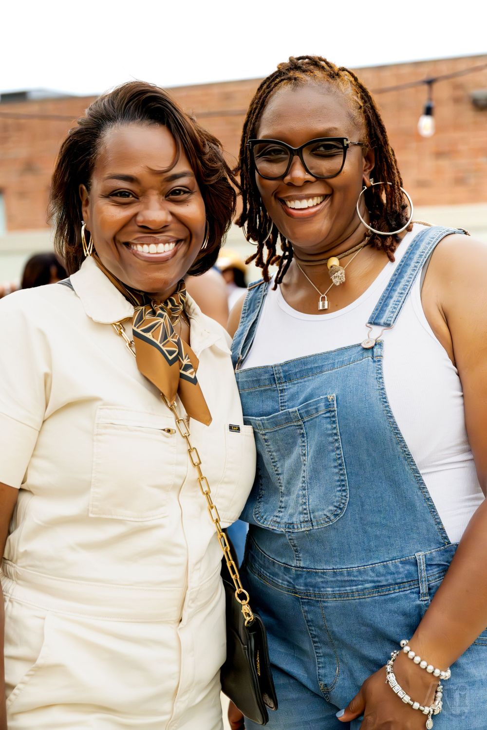 Two friends sharing a joyful moment together at an outdoor event.