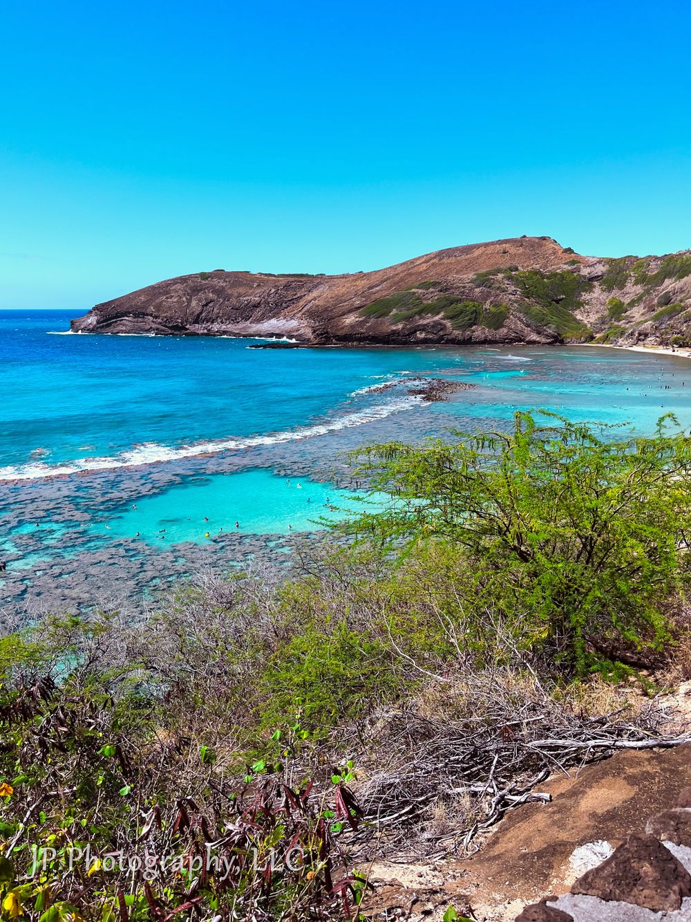 Stunning panorama of a tropical beach cove with turquoise waters and rocky coastline.