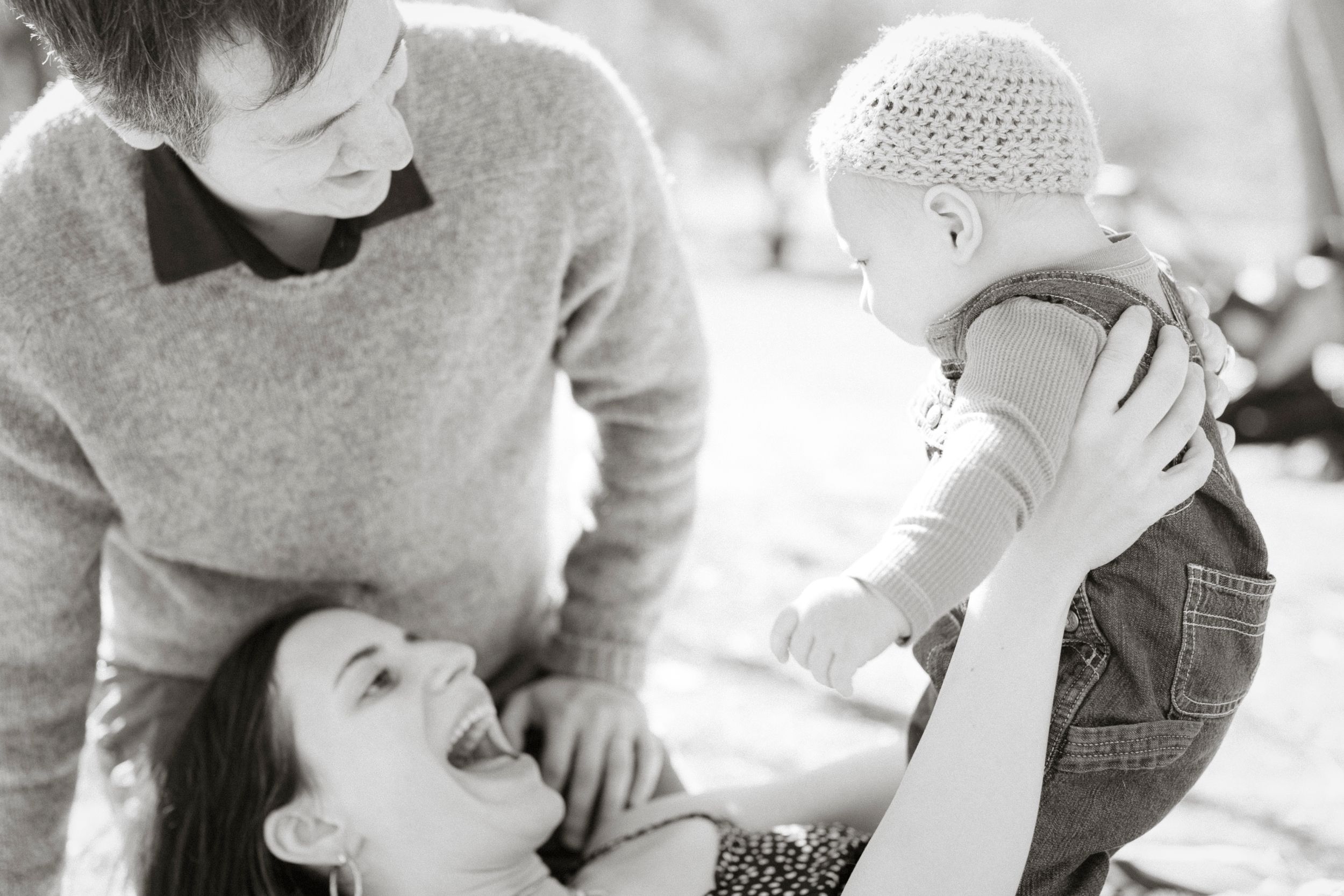 A joyful black and white family portrait taken outdoors.