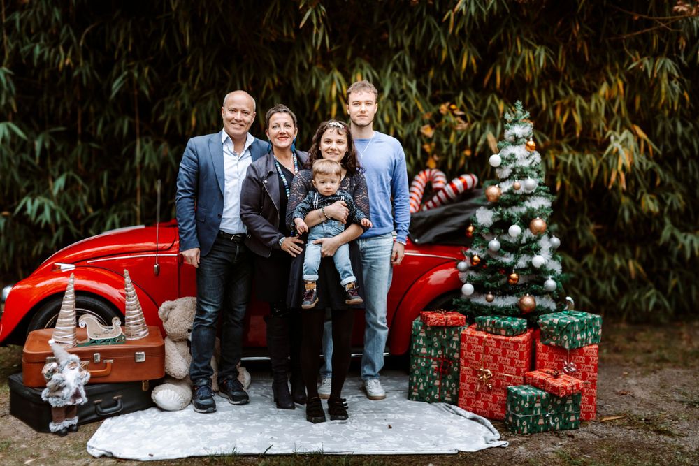 Mini-session photo de Noël 2024 avec une coccinelle VW rouge décorée pour les fêtes, créant une ambiance festive et chaleureuse.