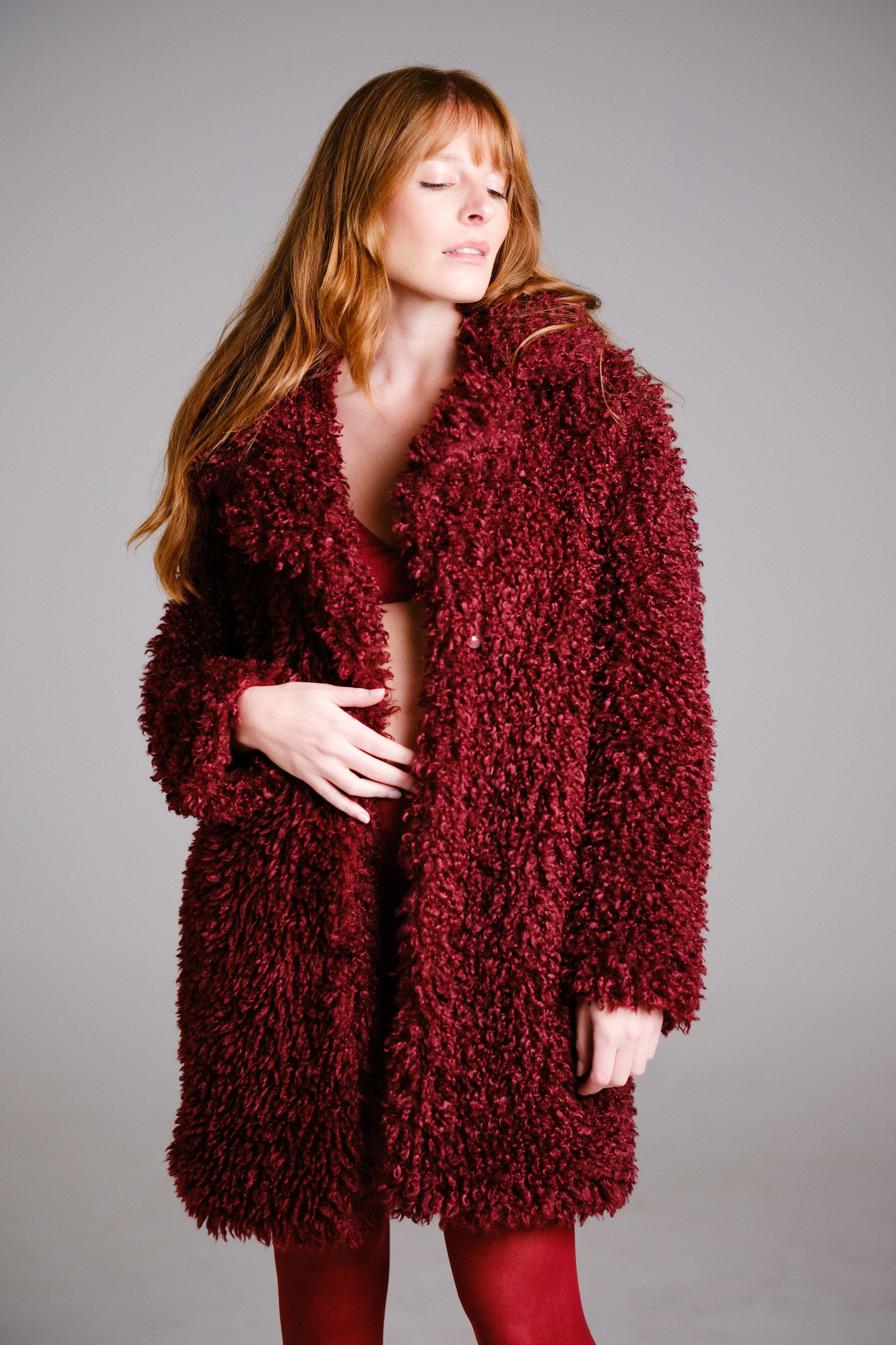 Fashion portrait series featuring luxurious burgundy textured coat and matching ensemble.