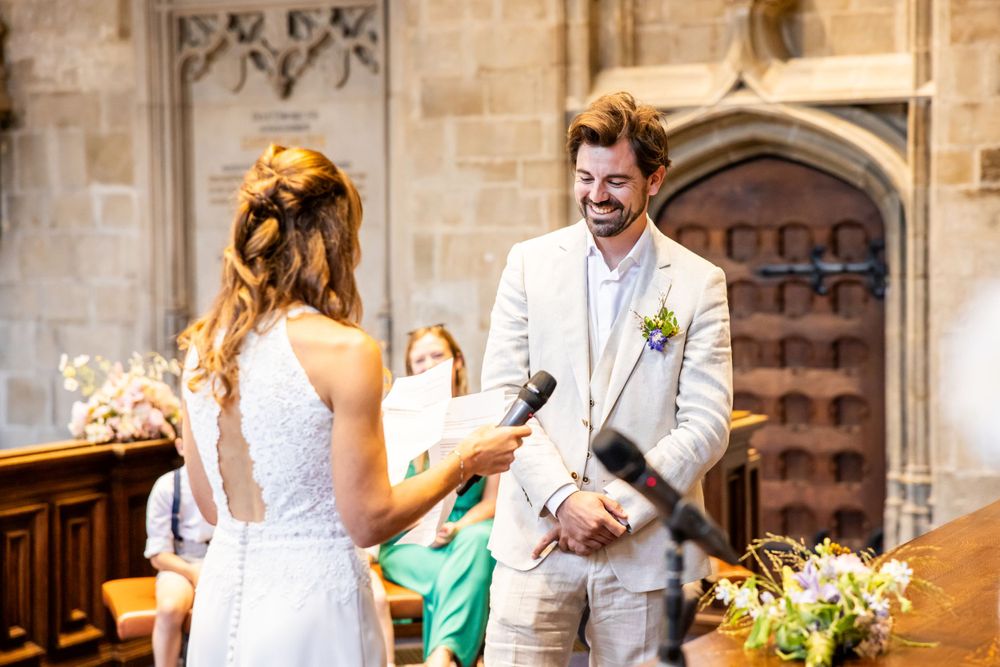 A joyful wedding ceremony takes place inside a historic stone church with Gothic architecture and floral decorations.