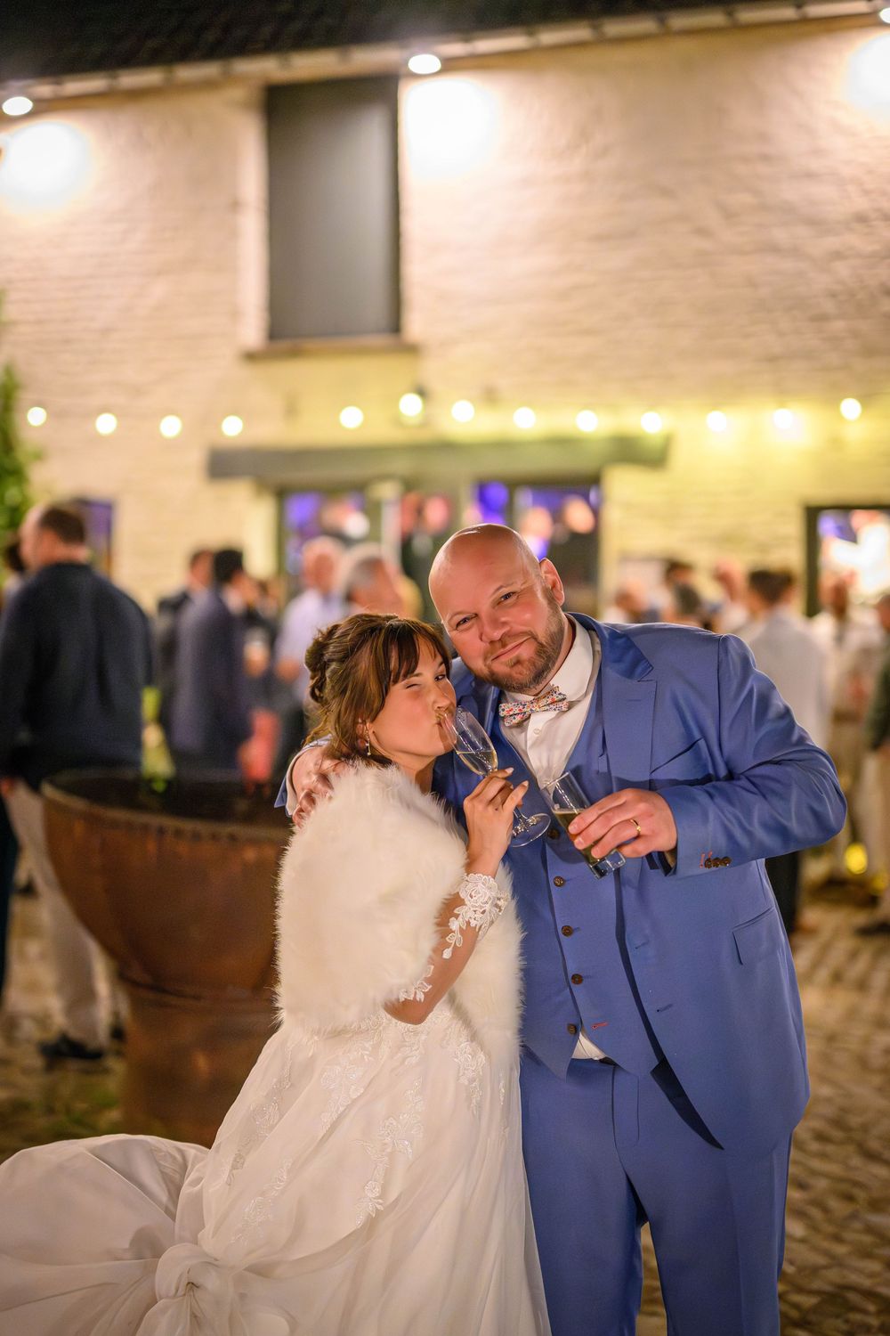 Newlywed couple dancing together at an indoor reception venue with warm lighting.