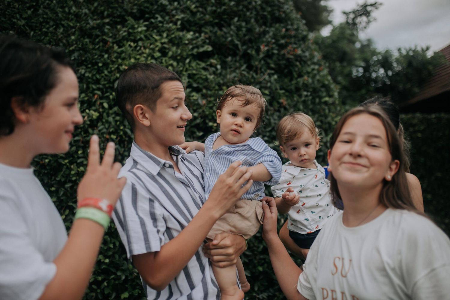 Group enjoying outdoor gathering with babies in casual summer attire.