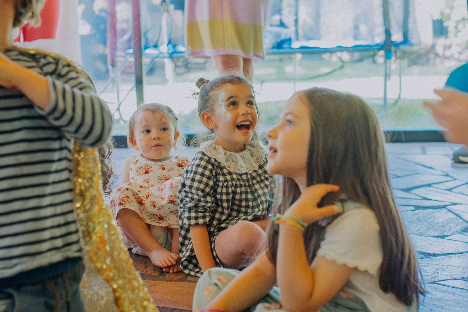 Children enjoying an animated moment at a lively party with colorful decorations in the background.