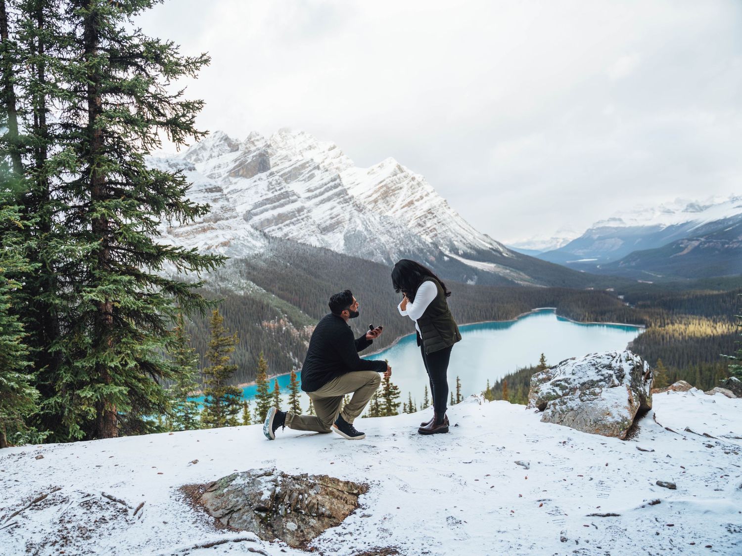Man proposes to a woman with mountains in the background. Banff mountain proposal.
