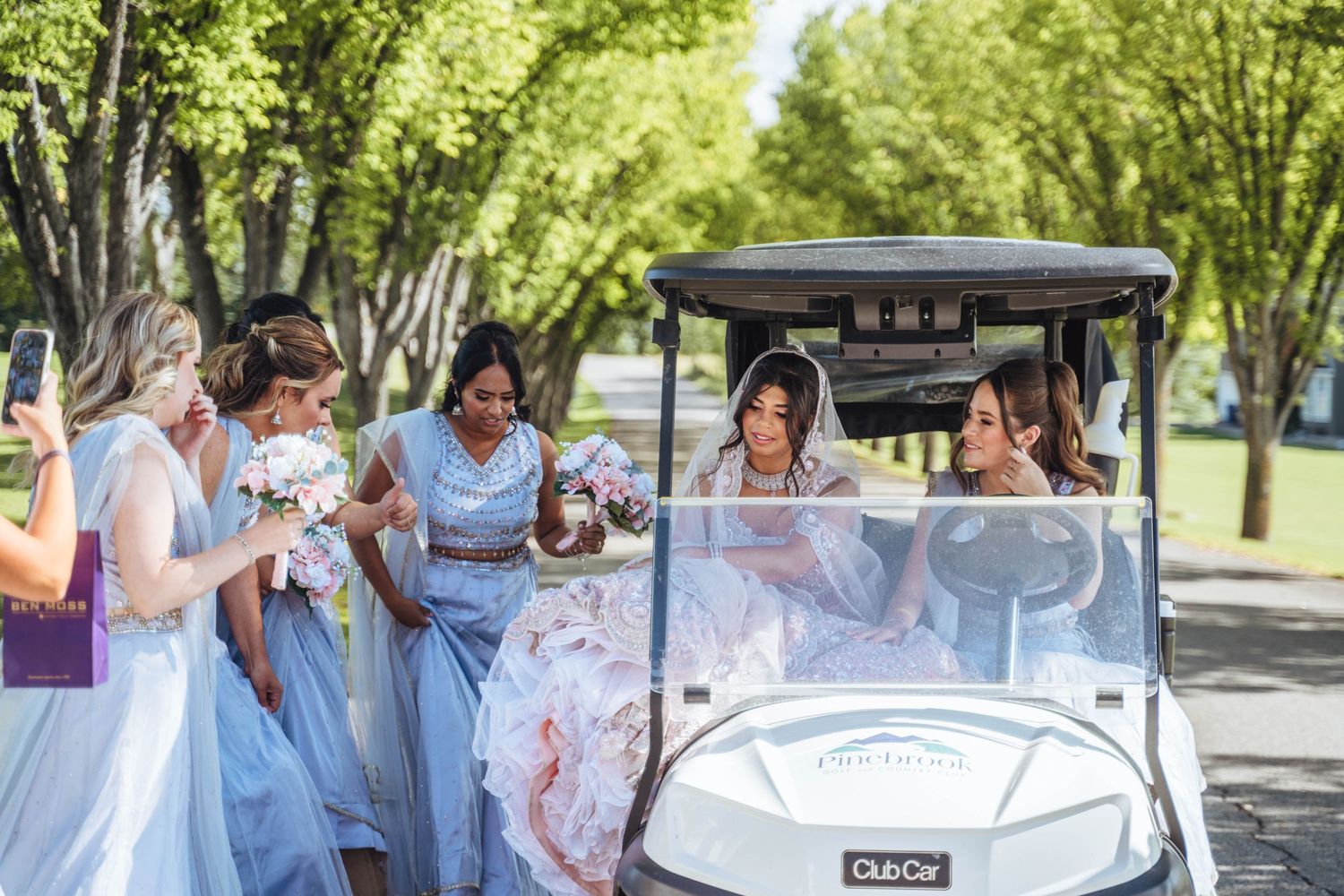 Bride arrives in a golf cart with bridesmaids. Calgary wedding.