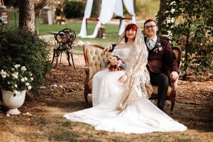 A romantic outdoor wedding photoshoot with a couple posing together in a garden setting among trees and natural scenery.
