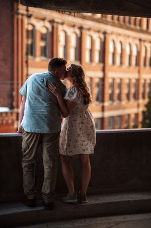 A couple shares a romantic moment silhouetted against a brick building during sunset near Alexandria's in Findlay, Ohio.