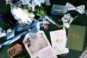 Wedding day details flatlay with photographs, ribbons and decorative elements.