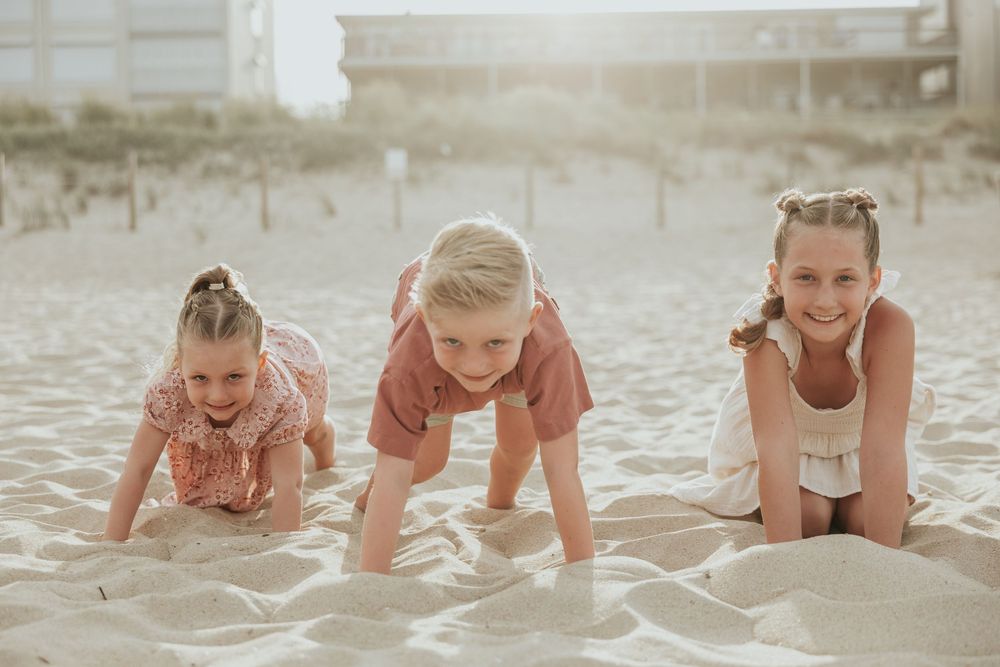 Series of candid shots showing playful crawling movements on a sandy beach at sunset.