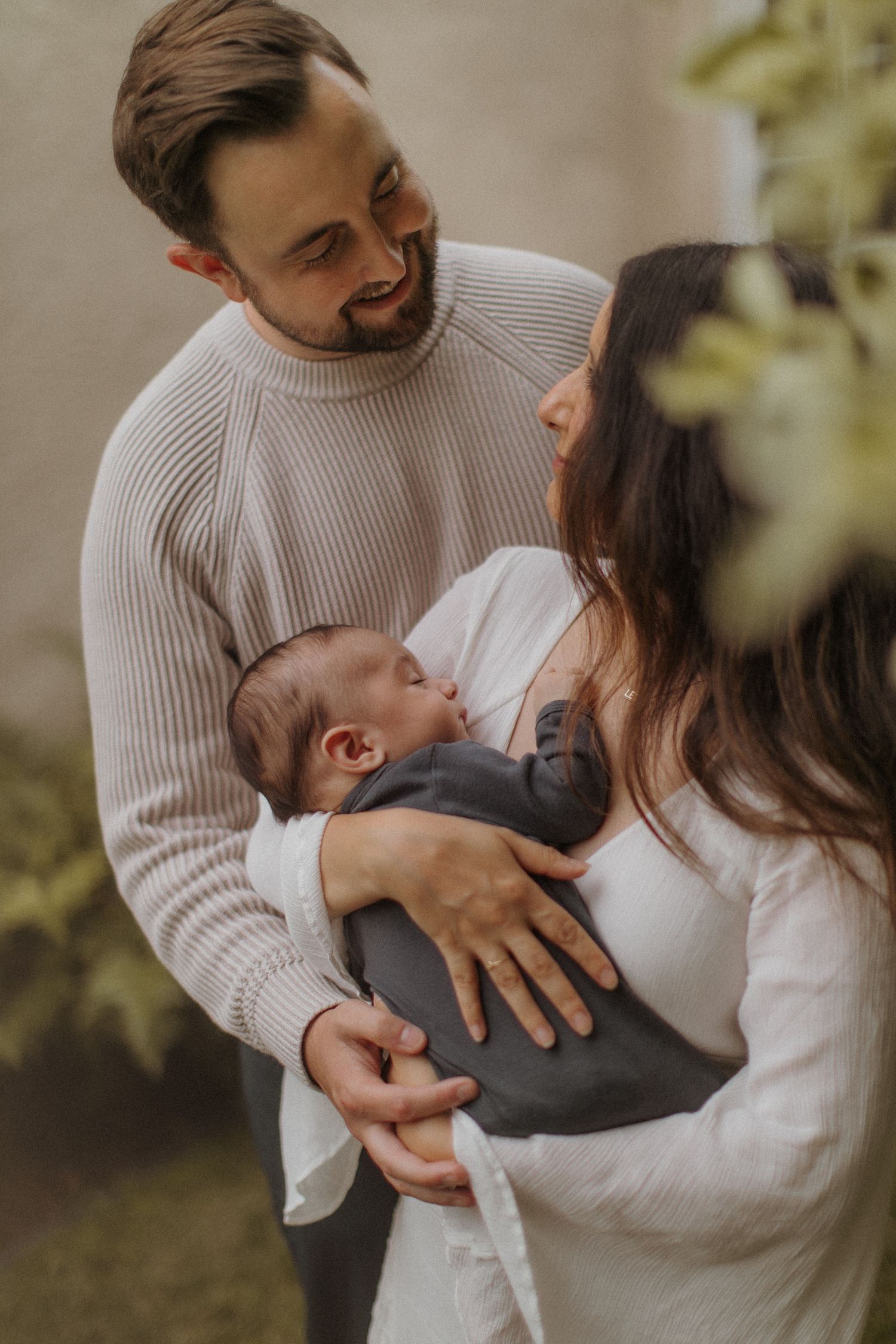 Gentle moments between parents and newborn in cozy white knitwear. San Diego Newborn Photographer.
