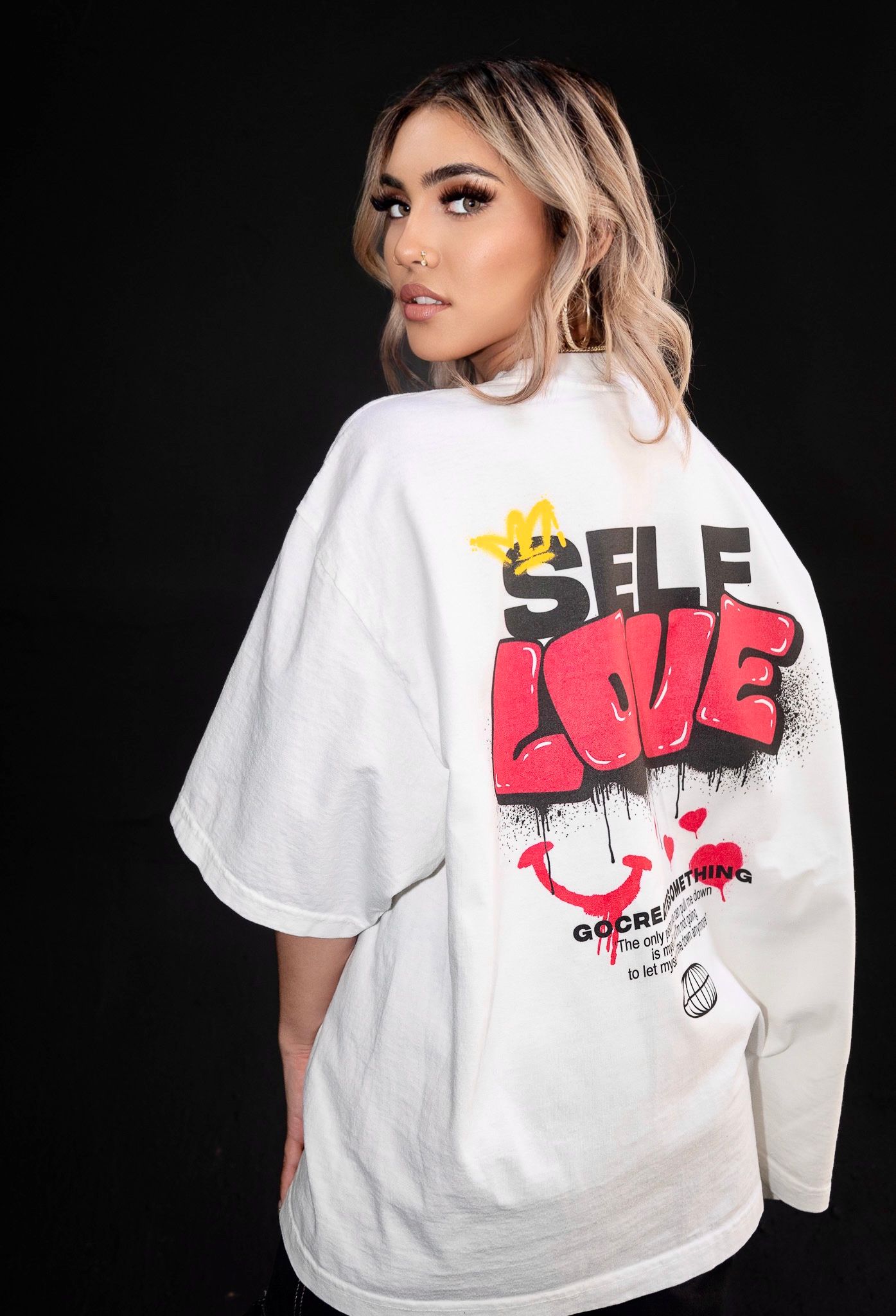 White oversized t-shirt with graffiti style 'Self Love' text design on back.