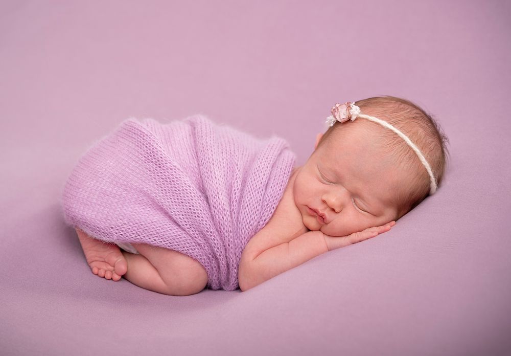in studio Baltimore Ontario sleeping newborn baby photoshoot posed on tummy with a purple soft knitted blanket*