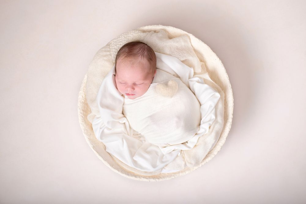 Newborn baby wrapped in white sleeping on white fluff in a white bowl prop, Cobourg baby photographer*