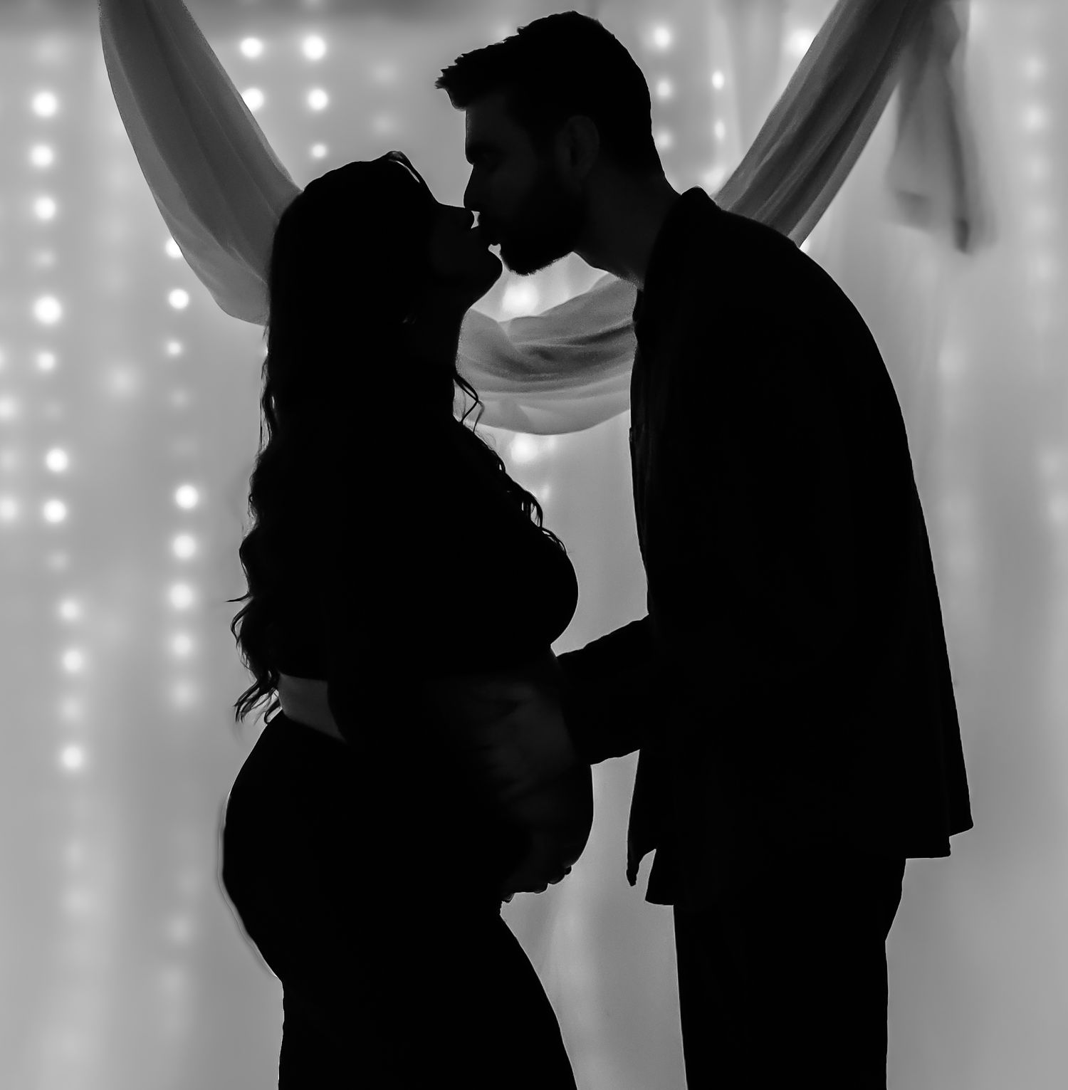 Silhouettes of dancing couples against a white twinkle light backdrop.