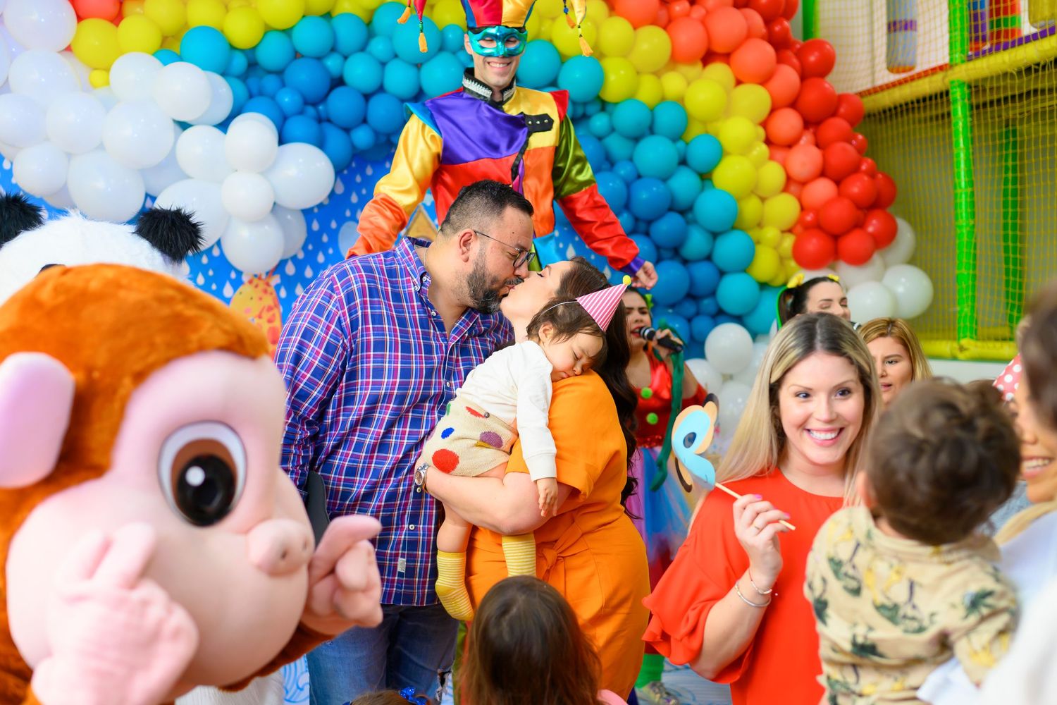 Colorful balloon arch and mascot costume at a cheerful children's indoor party celebration.