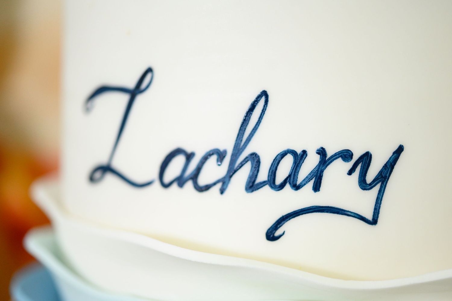 A close-up shot of the name 'Zachary' written in elegant blue cursive handwriting.