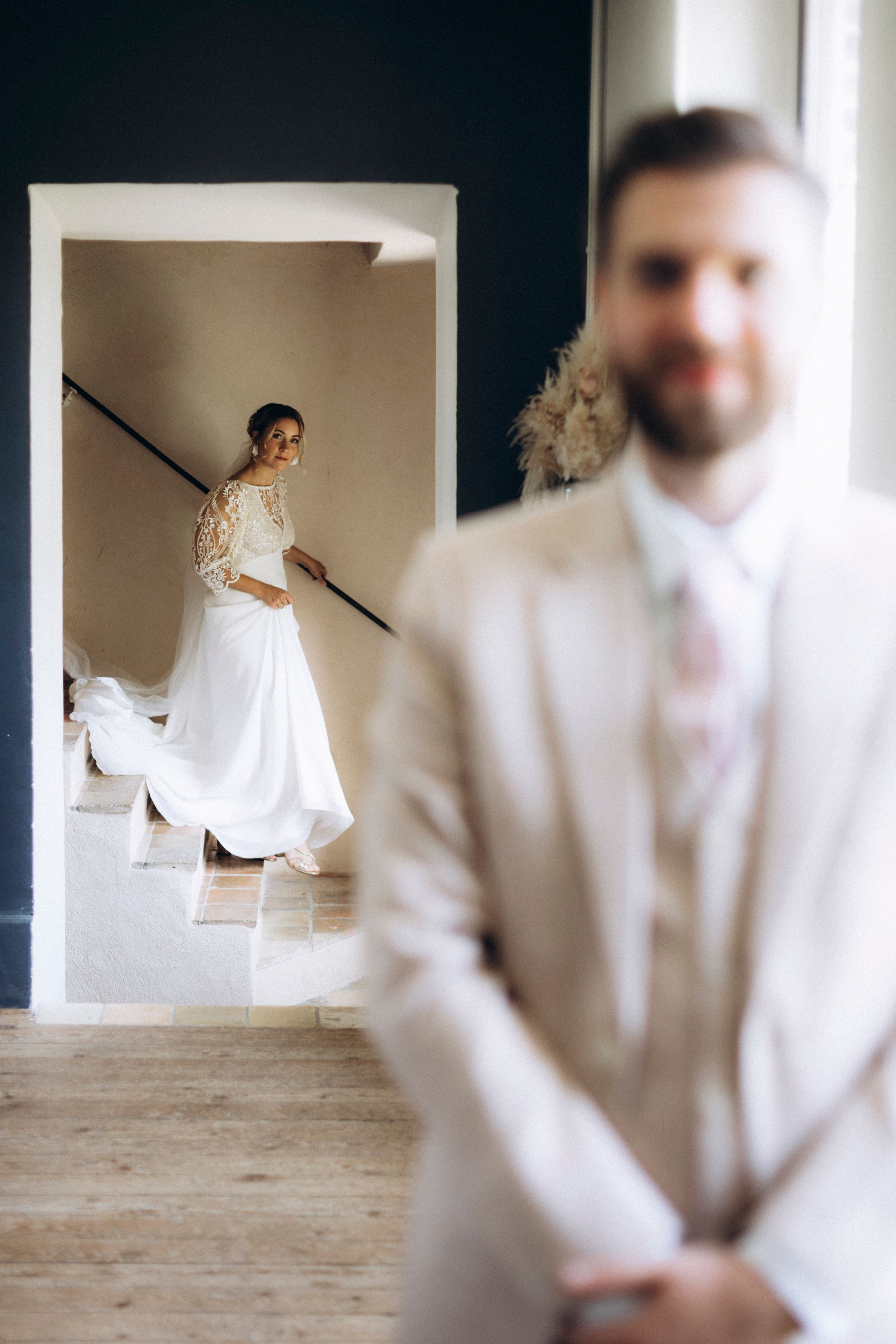 A series of artistic wedding photos showing blurred and focused shots of a couple in white attire on a rustic wooden floor.