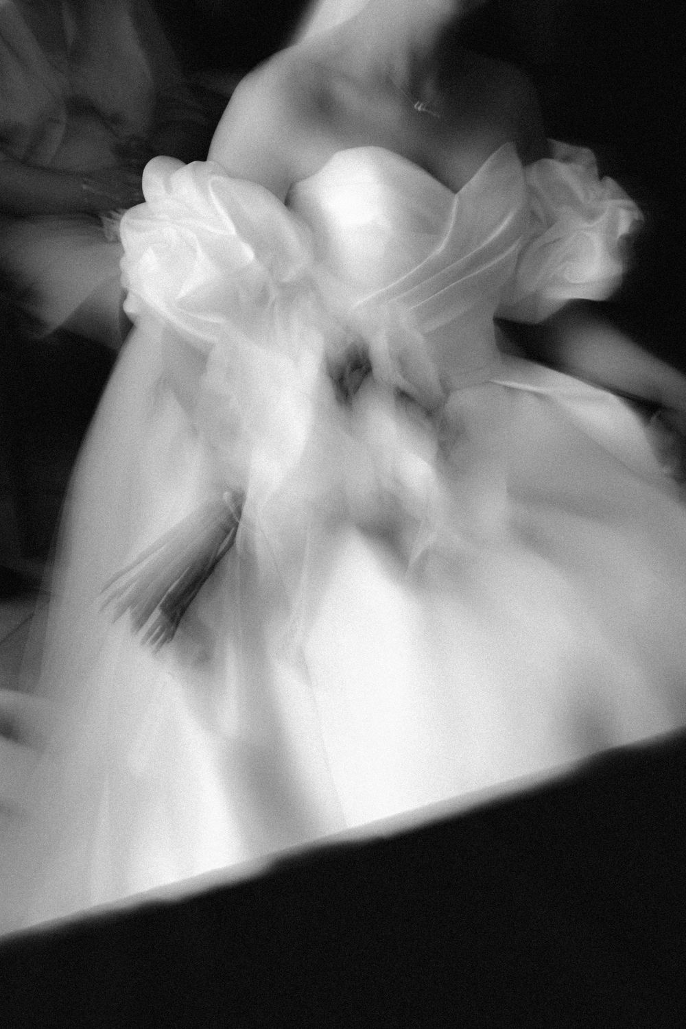 Abstract black and white photographs show ethereal flowing fabric or smoke creating dramatic light and shadow patterns.