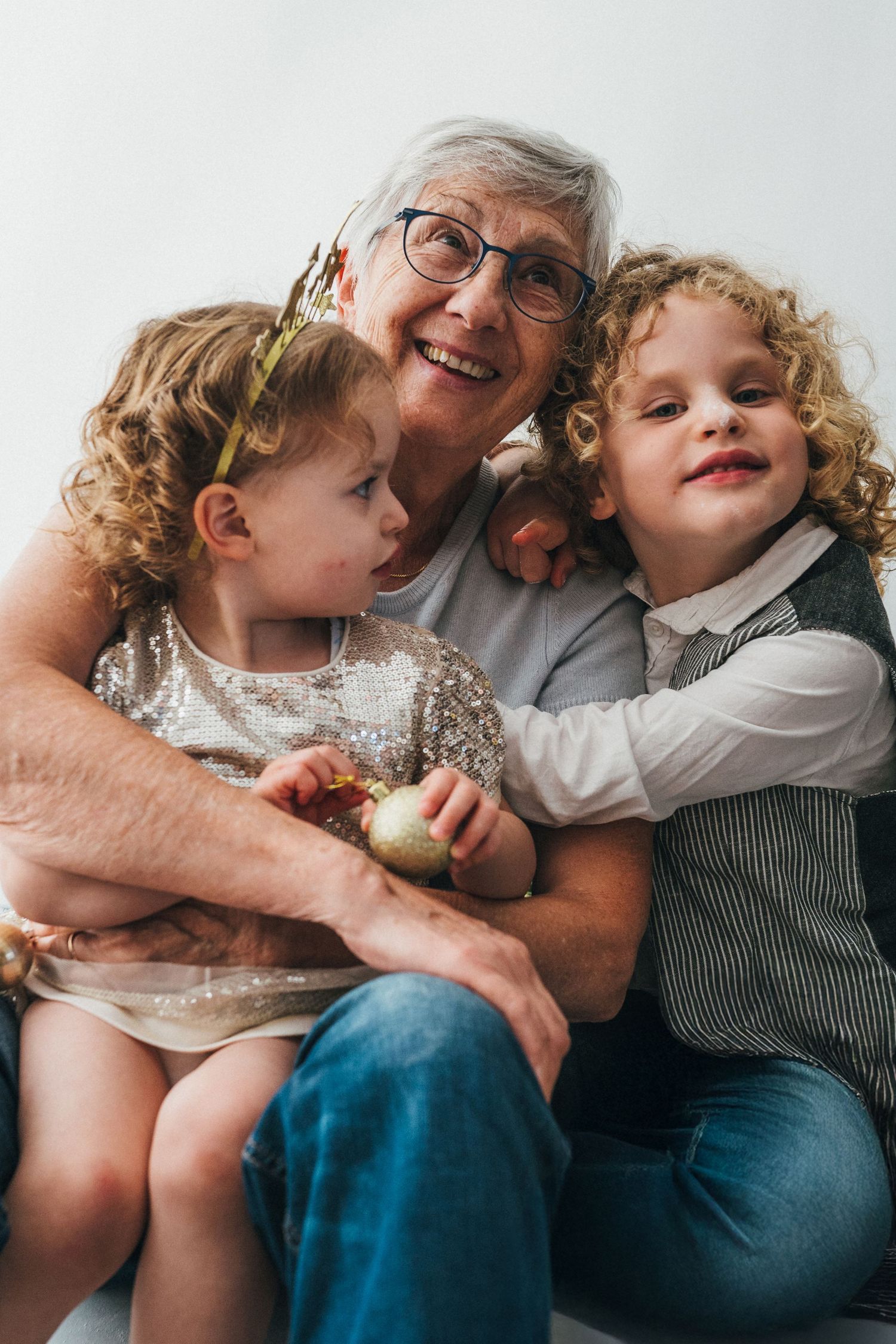 Une grand-mère souriante enlace ses petits-enfants lors d’une mini-séance photo de Noël à Fameck, dans une atmosphère douce et naturelle.