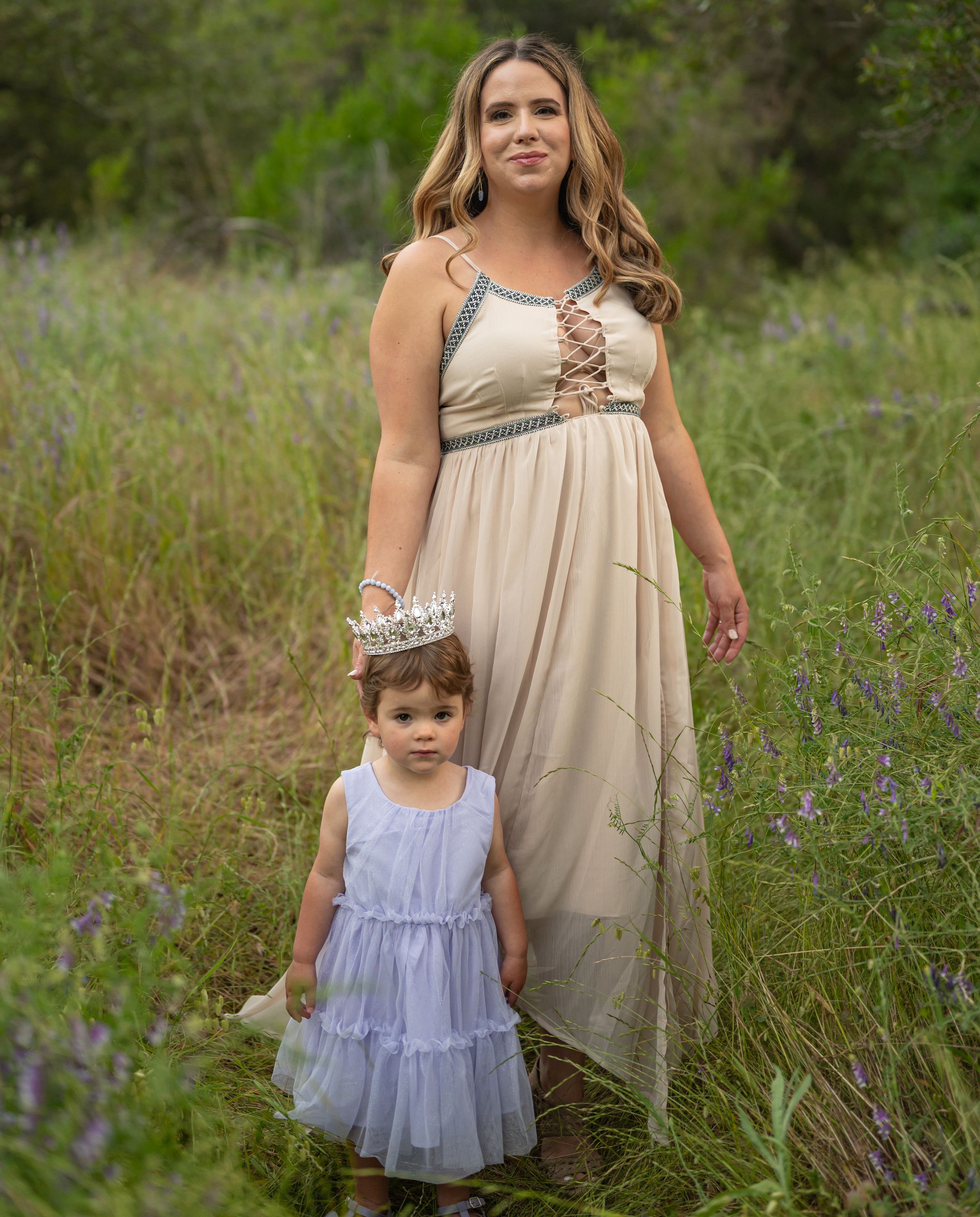 A heartwarming moment between two people in elegant dresses standing among wildflowers.