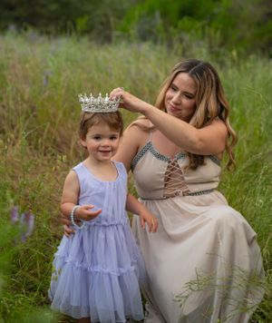 A touching outdoor photoshoot with matching crowns in a wildflower meadow.