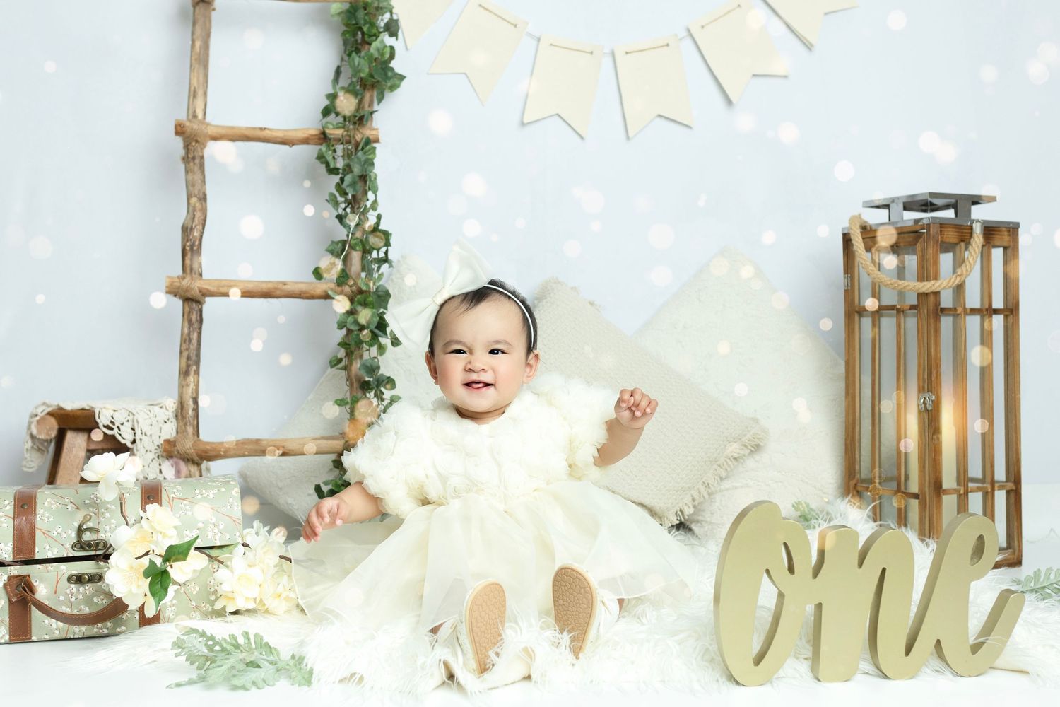 Rustic white and beige cake smash photography setup with wooden ladder and decorative elements.