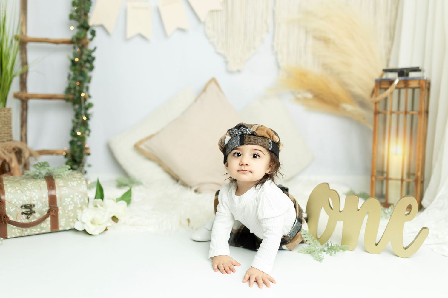 Vintage-inspired birthday photo setup with cream fabrics and wooden elements.