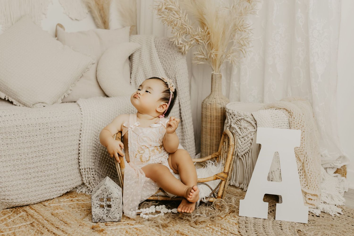 Neutral toned photography setup with boho decorations, dried pampas grass, and white textiles.
