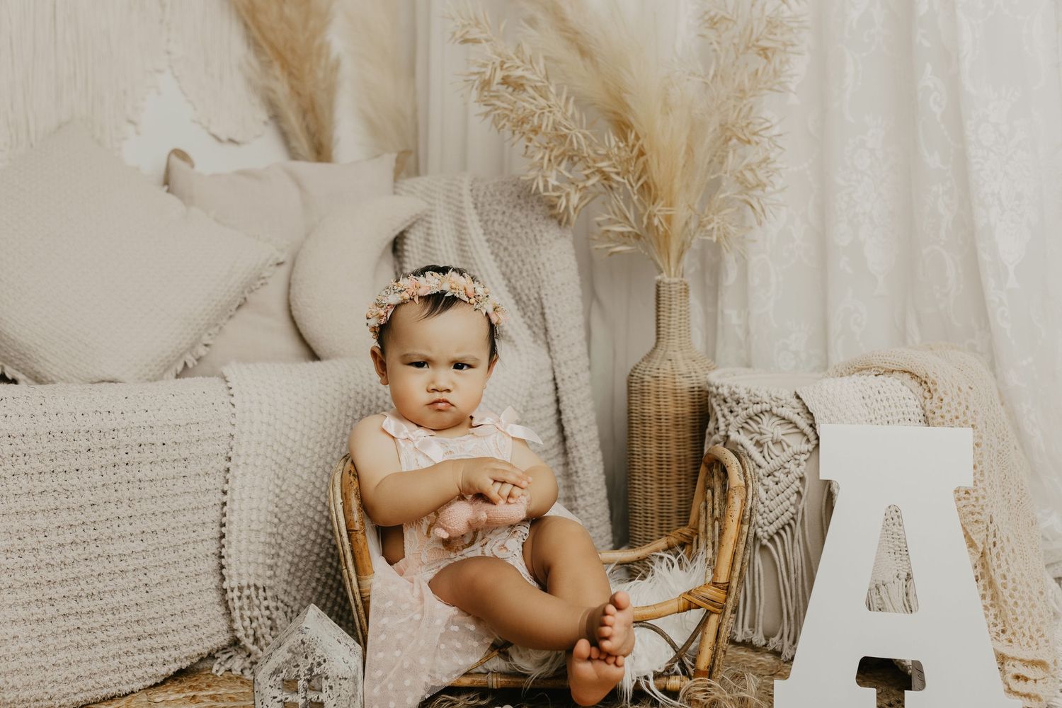 Minimalist first birthday photo setup with wooden elements and neutral color palette.