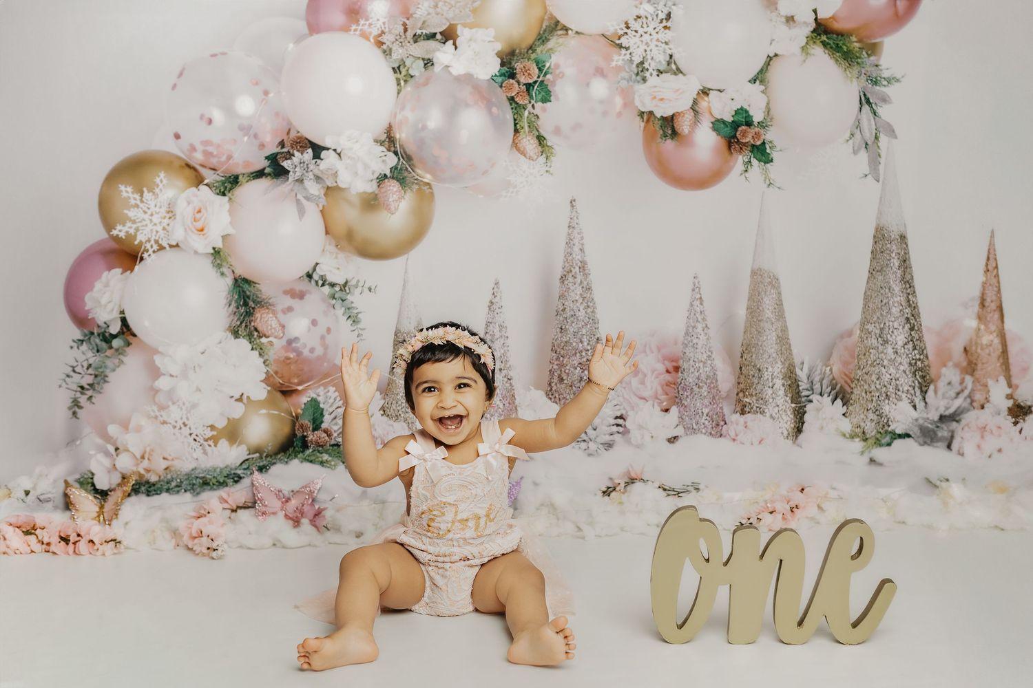 Elegant cake smash photo setup with pink and gold theme, featuring metallic trees and balloons.