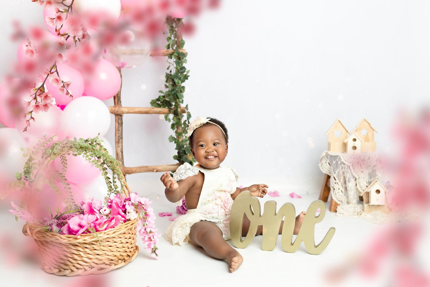 Pink floral themed photography setup with decorative basket and wooden elements.