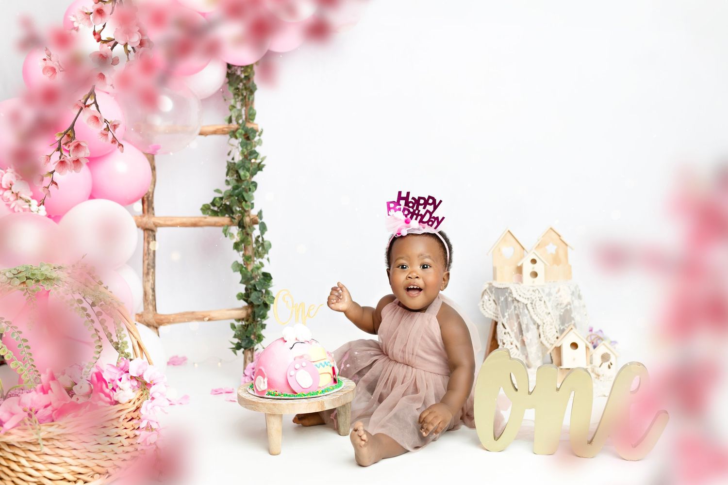 Dreamy pink photography setup with wooden props and floral accents.