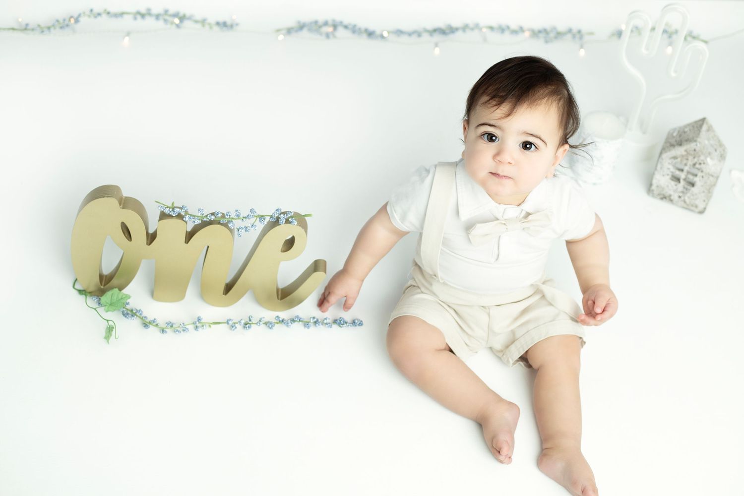 White minimalist photography setup with gold lettering and soft lighting.