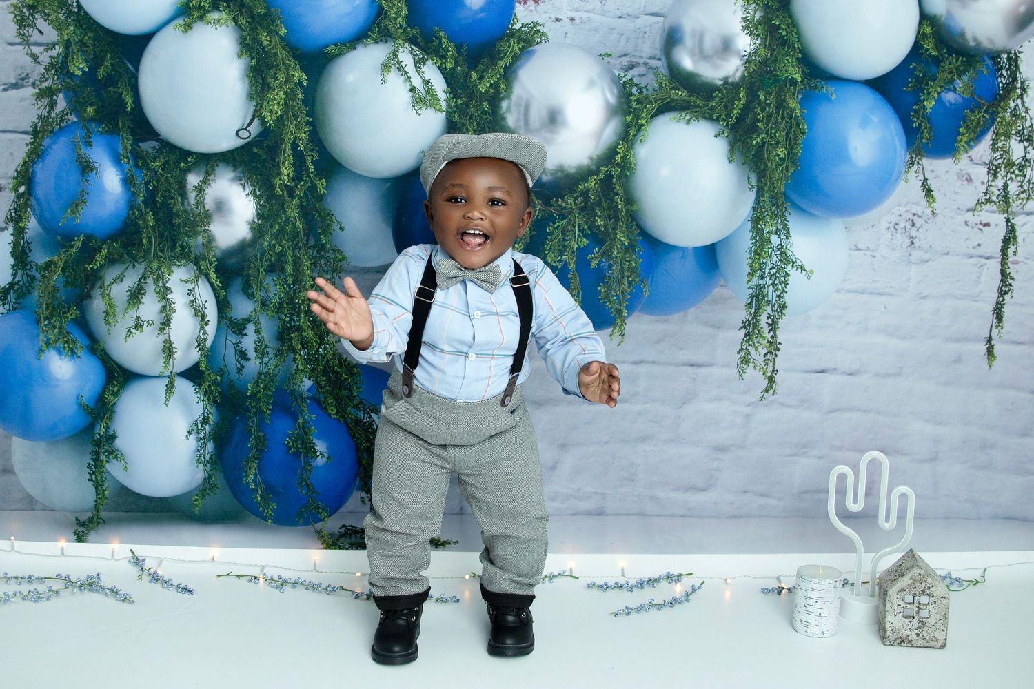 Winter themed photo setup with blue and white balloons and hanging greenery.