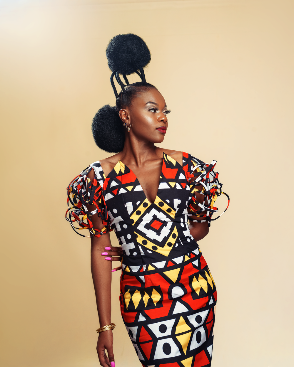A bold geometric print dress in red and black creates a striking silhouette against a neutral background.