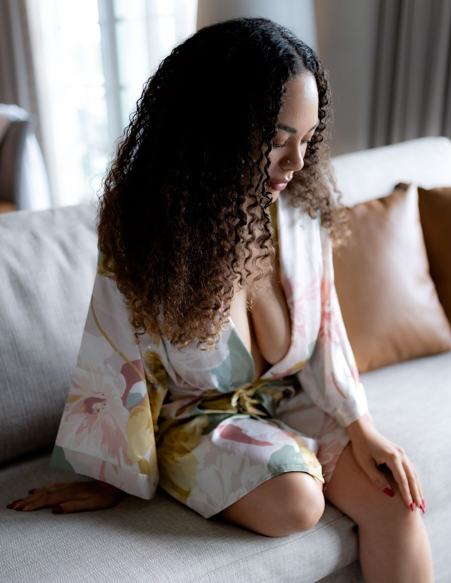 Casual indoor portrait in floral kimono on white couch.