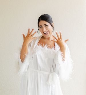 Close-up of hands raised against white fabric showing delicate detail.