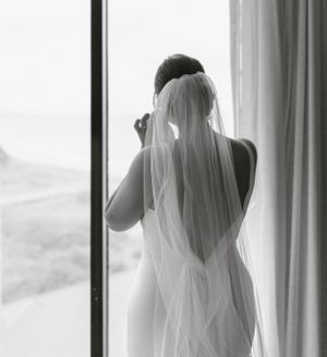 A candid black and white portrait showing joy during wedding preparations.