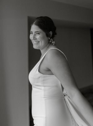 Black and white portrait of someone in a sleeveless white dress.