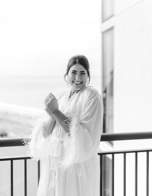 A joyful morning scene on a balcony showing preparations in a white robe.