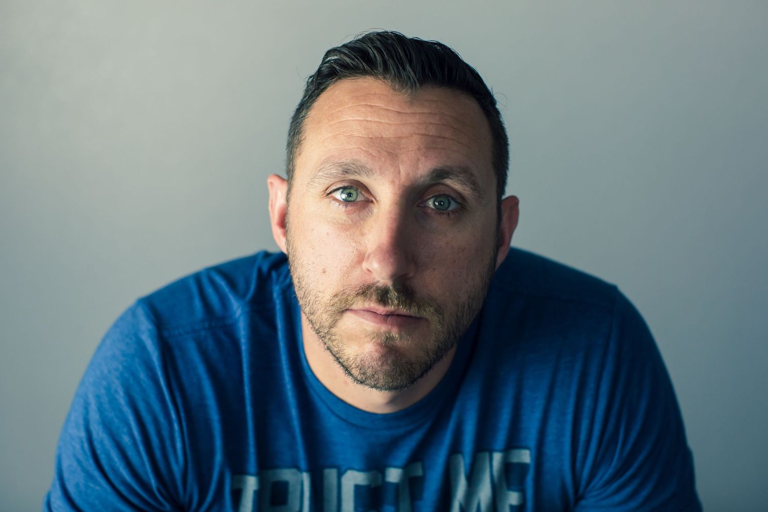 Professional portrait series of person in blue shirt against gray backdrop showing various poses.