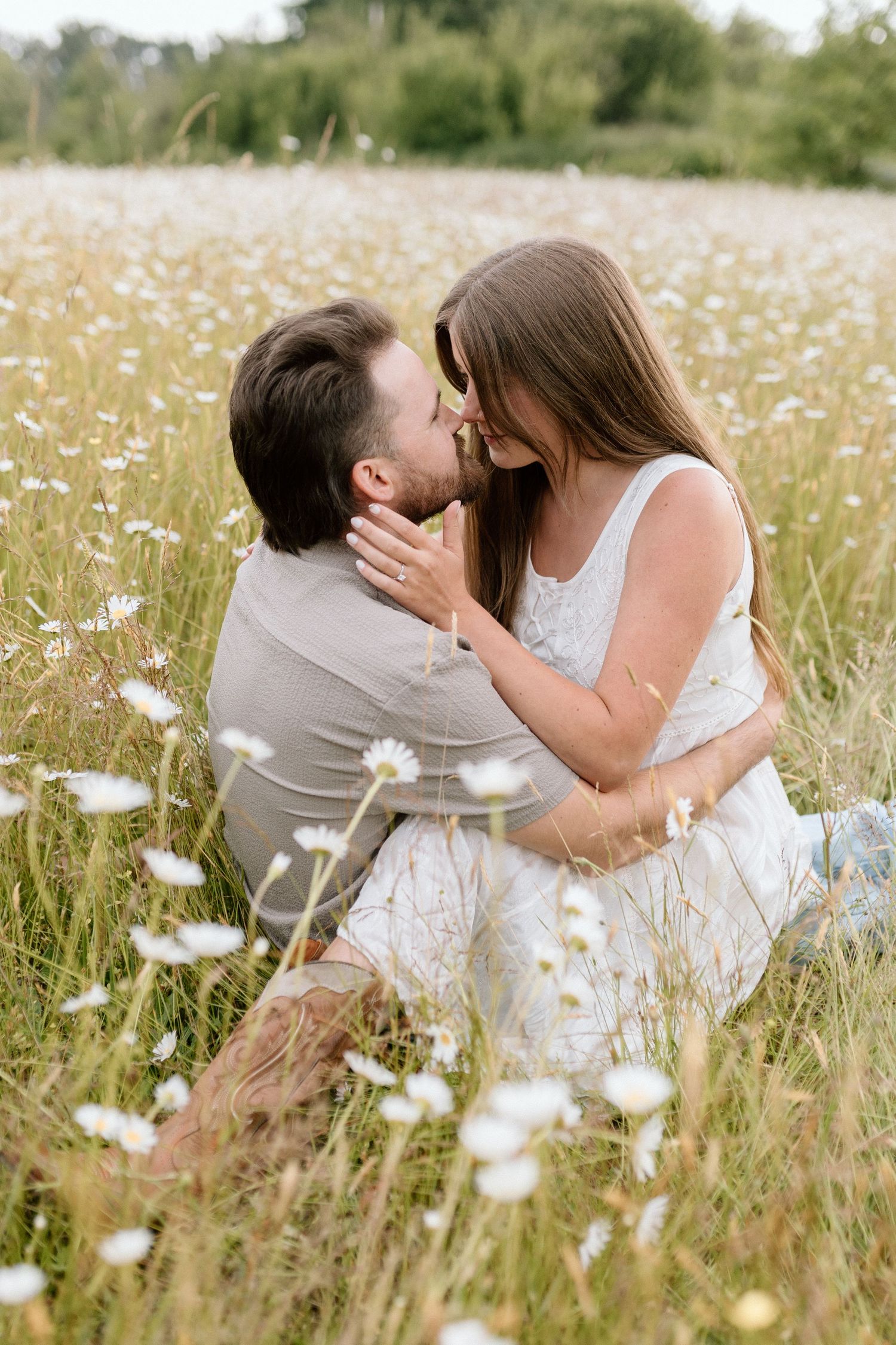 Intimate sunlit portrait of couple dancing in golden summer field.