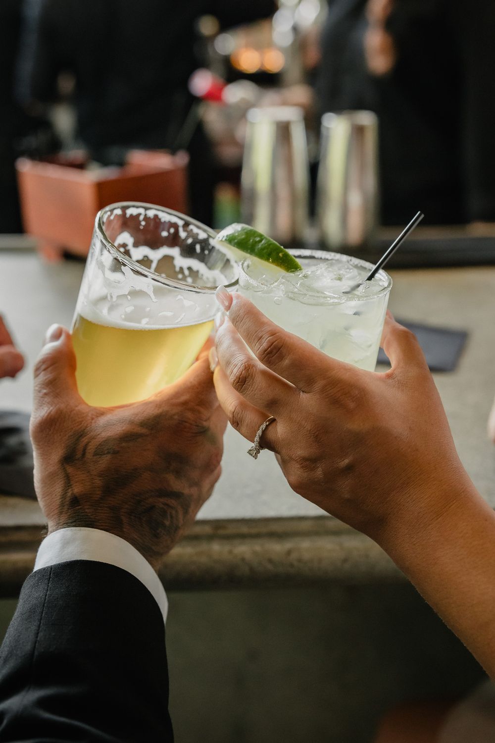 Wedding toast with beer and cocktail glasses clinking together in celebration.