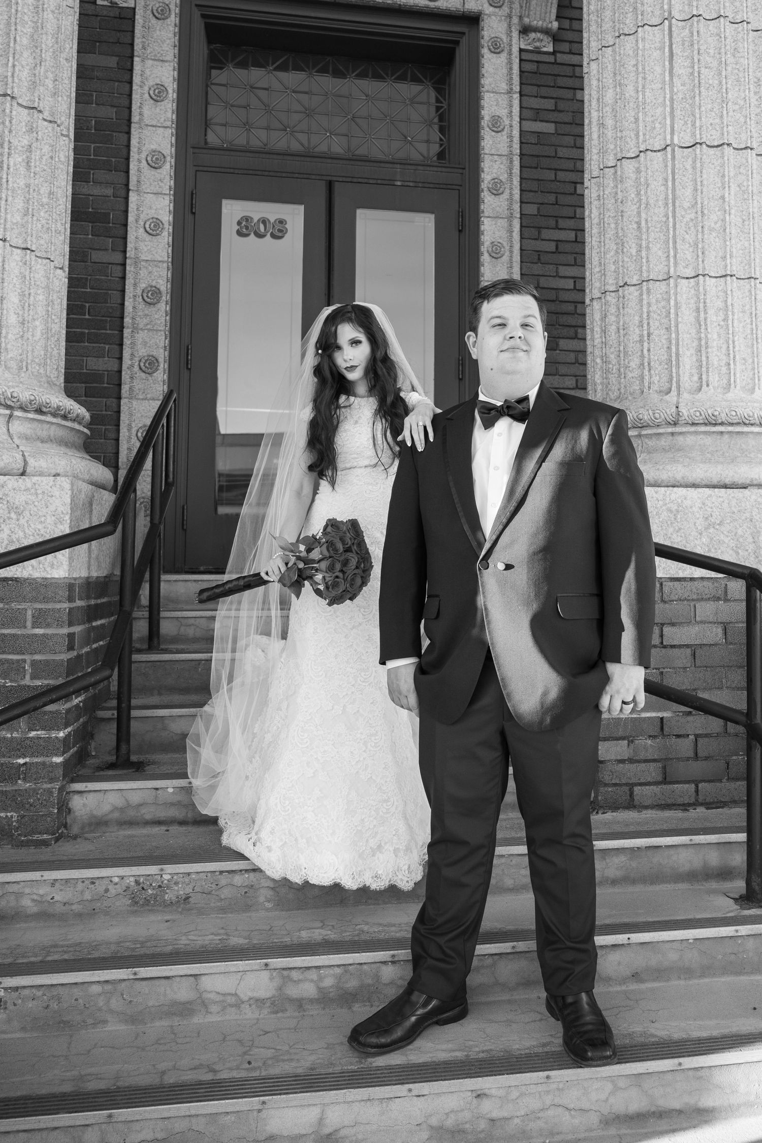 Romantic wedding portrait of couple on city hall steps
