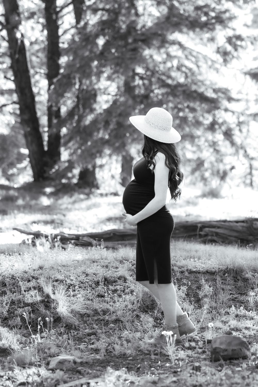 Black and white maternity portraits in the New Mexico Mountains, looking away from camera, focusing on baby bump